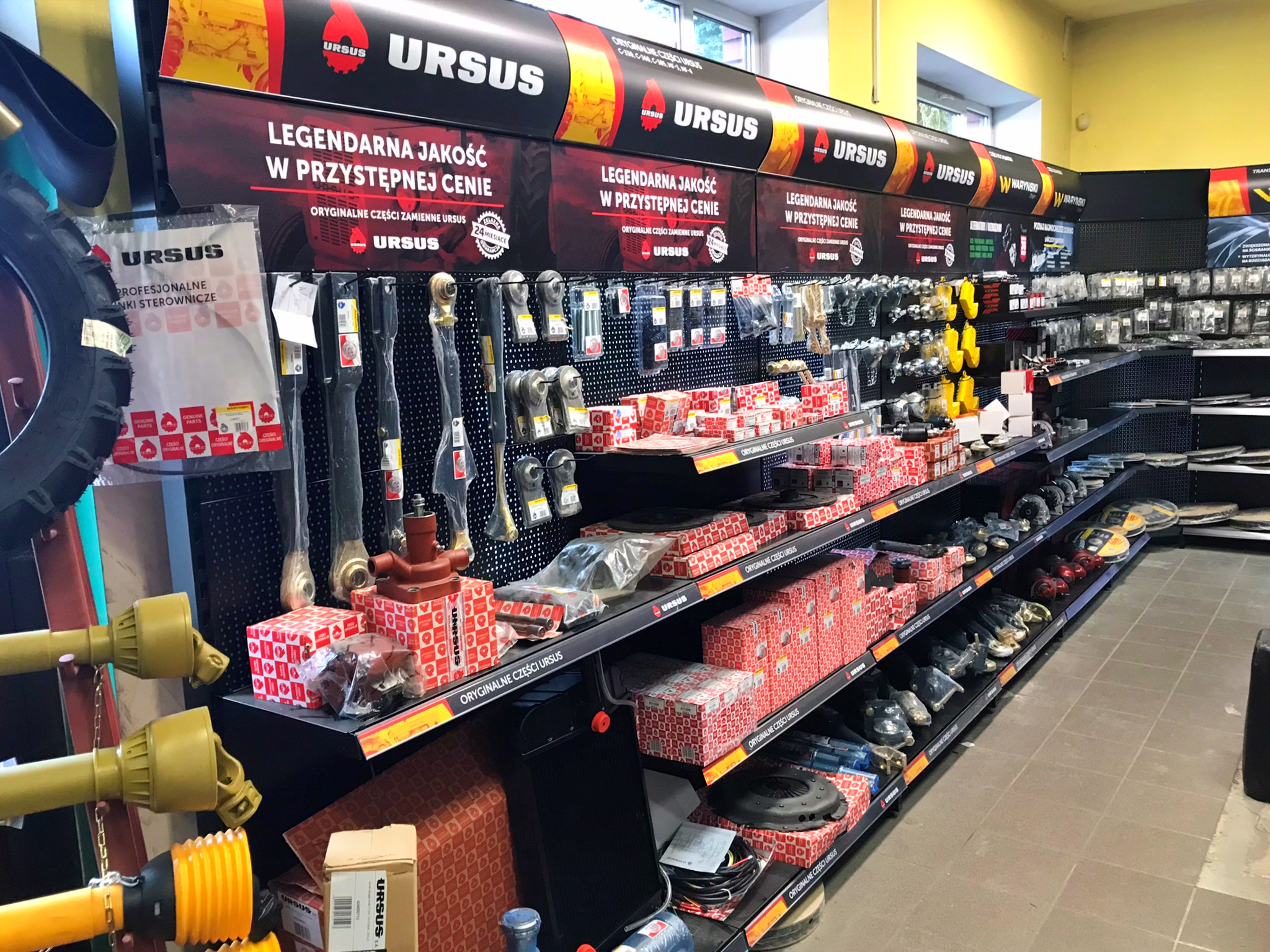 Shop layout visualization with black shelves, wooden pallets and yellow wall accents. The project shows a retail space with systematically arranged equipment elements, Rolmar logo in the bottom right corner